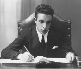 Juan Iglesias writing at his desk